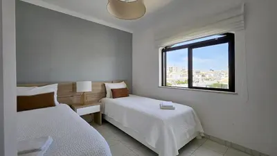 a bedroom with two beds and a window at Casa Catarina in Albufeira