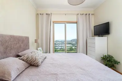 a bedroom with a large bed with two glass tables at BnB Homes Ocean view Apartment with comfortable Terrace, 2 Swimming pools & Tennis court in Albufeira