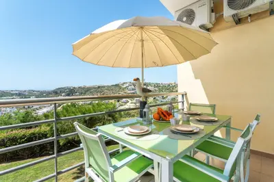 a swimming pool in a resort with palm trees and buildings at BnB Homes Ocean view Apartment with comfortable Terrace, 2 Swimming pools & Tennis court in Albufeira