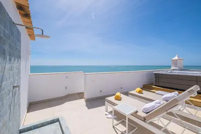 a balcony with chairs and a view of the ocean at Casa na Muralha - Beach front - Rooftop Jacuzzi by DreamvillasAlbufeira in Albufeira
