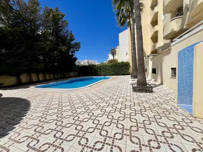 a tile walkway next to a building with a swimming pool at Albufeira Marina Sol With Pool by Homing in Albufeira