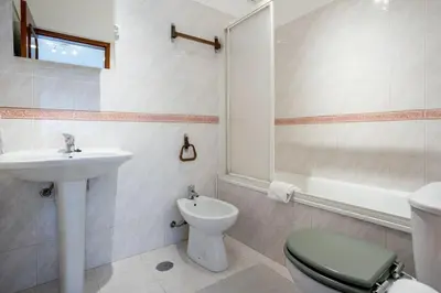 a white bathroom with a sink and a toilet at Blife Allya private rooms in Faro