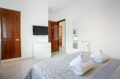 a white bedroom with a bed with towels on it at Blife Allya private rooms in Faro