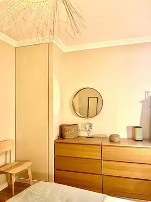 a bedroom with a mirror and a wooden dresser at Casa da vila in Faro