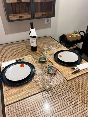 two plates and glasses on a table with a bottle of wine at Casa da vila in Faro