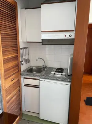 a kitchen with white cabinets and a sink at Estúdio Vista Mar em Vilamoura in Quarteira