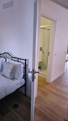 an open door to a bedroom with a bed and a mirror at Carmo City Center 3 in Faro