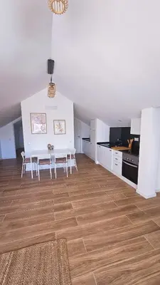 a living room with a table and chairs and a kitchen at Carmo City Center 3 in Faro