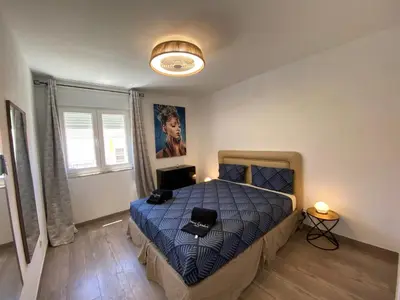 a bedroom with a bed with a blue comforter at Casa eden garden in Albufeira
