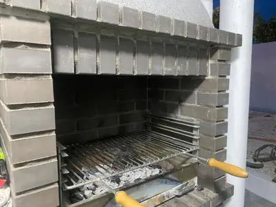 a barbecue grill in the side of a building at Casa eden garden in Albufeira