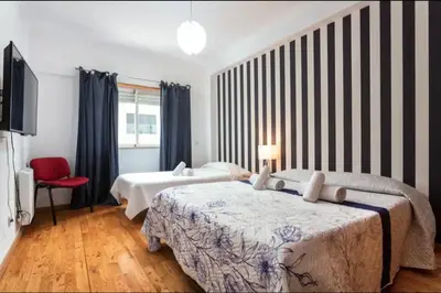 a hotel room with two beds and a television at Blife Candya private rooms in Faro