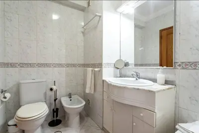 a white bathroom with a toilet and a sink at Blife Candya private rooms in Faro