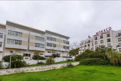 a large apartment building with a green lawn in front of it at Blife Candya private rooms in Faro