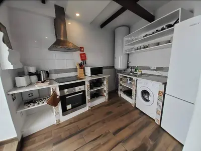 a kitchen with a stove and a washer and dryer at Blife Castelya private rooms in Faro