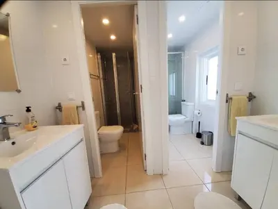 a white bathroom with a toilet and a sink at Blife Castelya private rooms in Faro