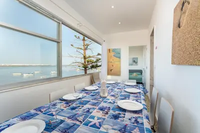 a dining room with a table with a view of the ocean at Blife Faya private rooms in Faro