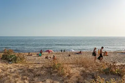 a group of people standing on a beach at Blife Faya private rooms in Faro