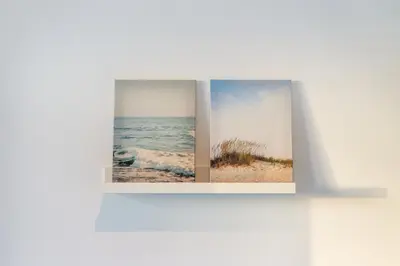 two photographs of a beach and the ocean on a wall at Blife Faya private rooms in Faro
