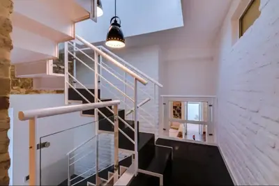 a staircase in a loft with a light fixture at Blife Frankya private rooms in Faro