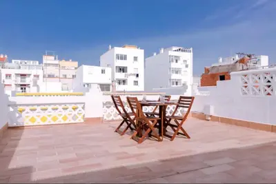 a table and chairs on the roof of a building at Blife Frankya private rooms in Faro