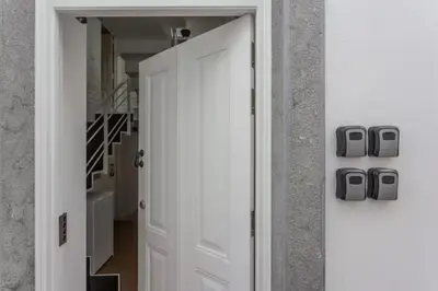 a white door leading into a hallway with a staircase at Blife Galya private rooms in Faro