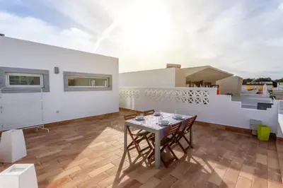a patio with a table and chairs on a roof at Blife Galya private rooms in Faro
