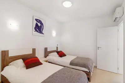 two beds in a room with white walls at Townhouse Ramas in Vale do Lobo