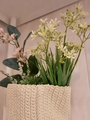 a white vase with white flowers in it at Blife Macaya private rooms in Monte Negro