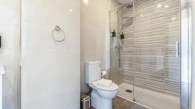 a white bathroom with a toilet and a shower at Modern Retreat 1 in Faro by Lovelystay in Faro