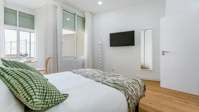 a bedroom with a bed and a tv on a wall at Modern Retreat 1 in Faro by Lovelystay in Faro