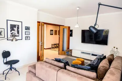 a living room with a couch and a flat screen tv at Casa Gulbenkian - Modern apartment by HD in Faro
