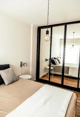 a bedroom with a bed and a large mirror at Casa Gulbenkian - Modern apartment by HD in Faro