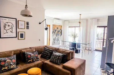 a living room with a brown couch and a table at Casa Gulbenkian - Modern apartment by HD in Faro