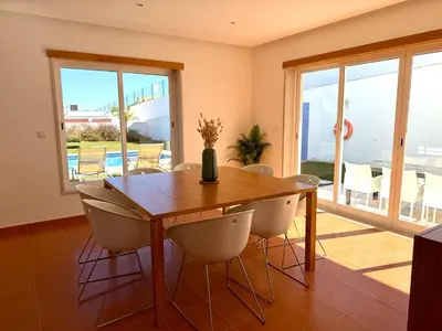 a living room with chairs and a couch and a table at Vila Noélia in Albufeira