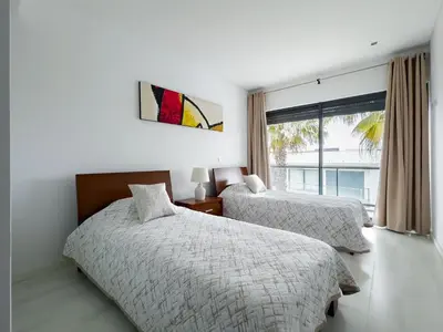 a bedroom with two beds and a window at Стильный апартамент Т2 Quarteira in Quarteira