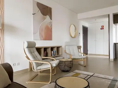 a living room with two chairs and a table at Стильный апартамент Т2 Quarteira in Quarteira