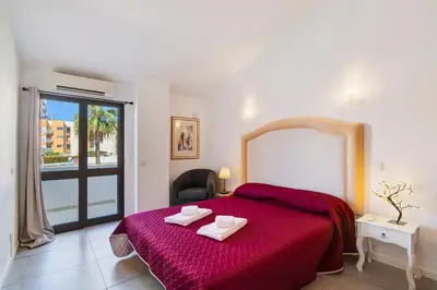 a bedroom with a large bed with a red blanket at Casa Sol in Quarteira