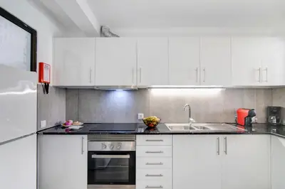 a kitchen with white cabinets and a sink at Casa Sol in Quarteira