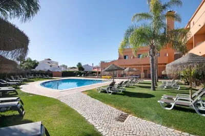 a swimming pool with lounge chairs and a resort at Casa Sol in Quarteira
