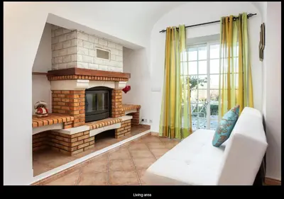 a living room with a fireplace and a white couch at Blife Moustachya private rooms in Faro