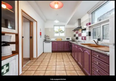 a kitchen with purple cabinets and a tile floor at Blife Moustachya private rooms in Faro