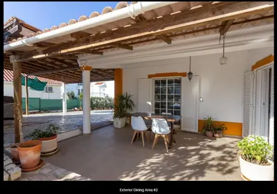 a patio with a table and chairs under a pergola at Blife Moustachya private rooms in Faro