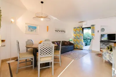 a dining room and living room with a table and chairs at Acolhedora Vila 371, 3 quartos, Balaia Golf Village in Albufeira