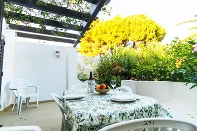 a white chair in the yard of a house at Acolhedora Vila 371, 3 quartos, Balaia Golf Village in Albufeira