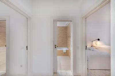 a white bedroom with a bed and a bathroom at Vilamouratenis Wave by SAPvillas in Vilamoura