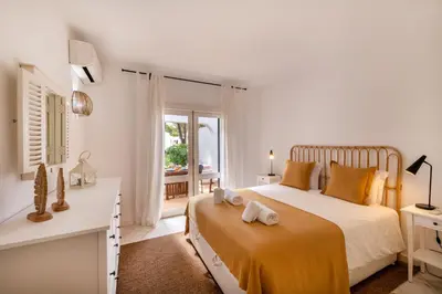 a bedroom with a bed and a desk and a window at Vilamouratenis Wave by SAPvillas in Vilamoura