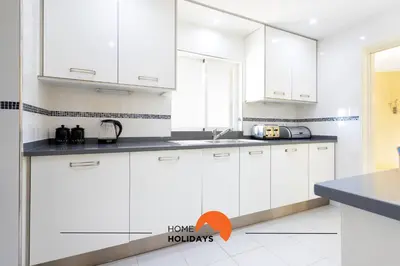 a white kitchen with white cabinets and a sink at #214 Vivenda 3 Quartos by Home Holidays in Albufeira