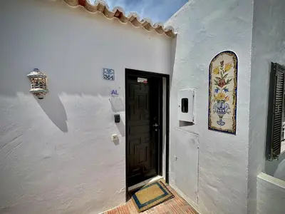 a white building with a black door and a window at Albufeira Balaia Golf Vilage 5 With Pool by Homing in Albufeira