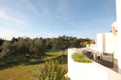 a kitchen with white cabinets and a sink and a window at Albufeira Balaia Golf Vilage 6 With Pool by Homing in Albufeira