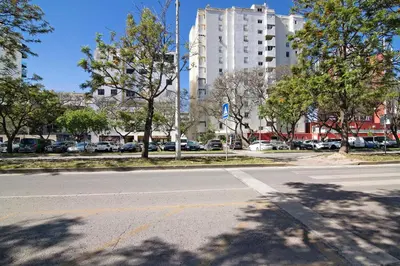 an empty street with cars parked in a parking lot at Apartamento Sunny in Quarteira